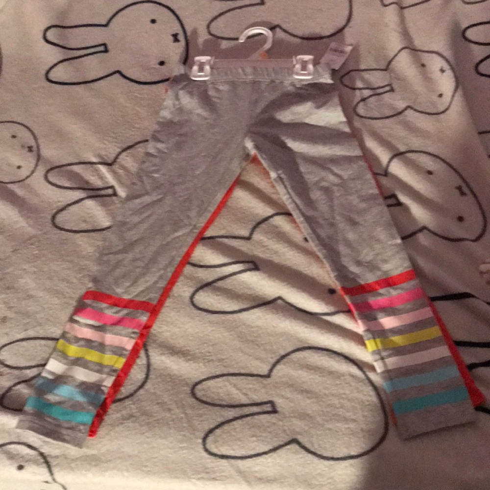 Two pairs of pants on grey with strip and red pair